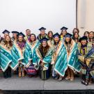 Native American graduates on stage with Pendleton blankets